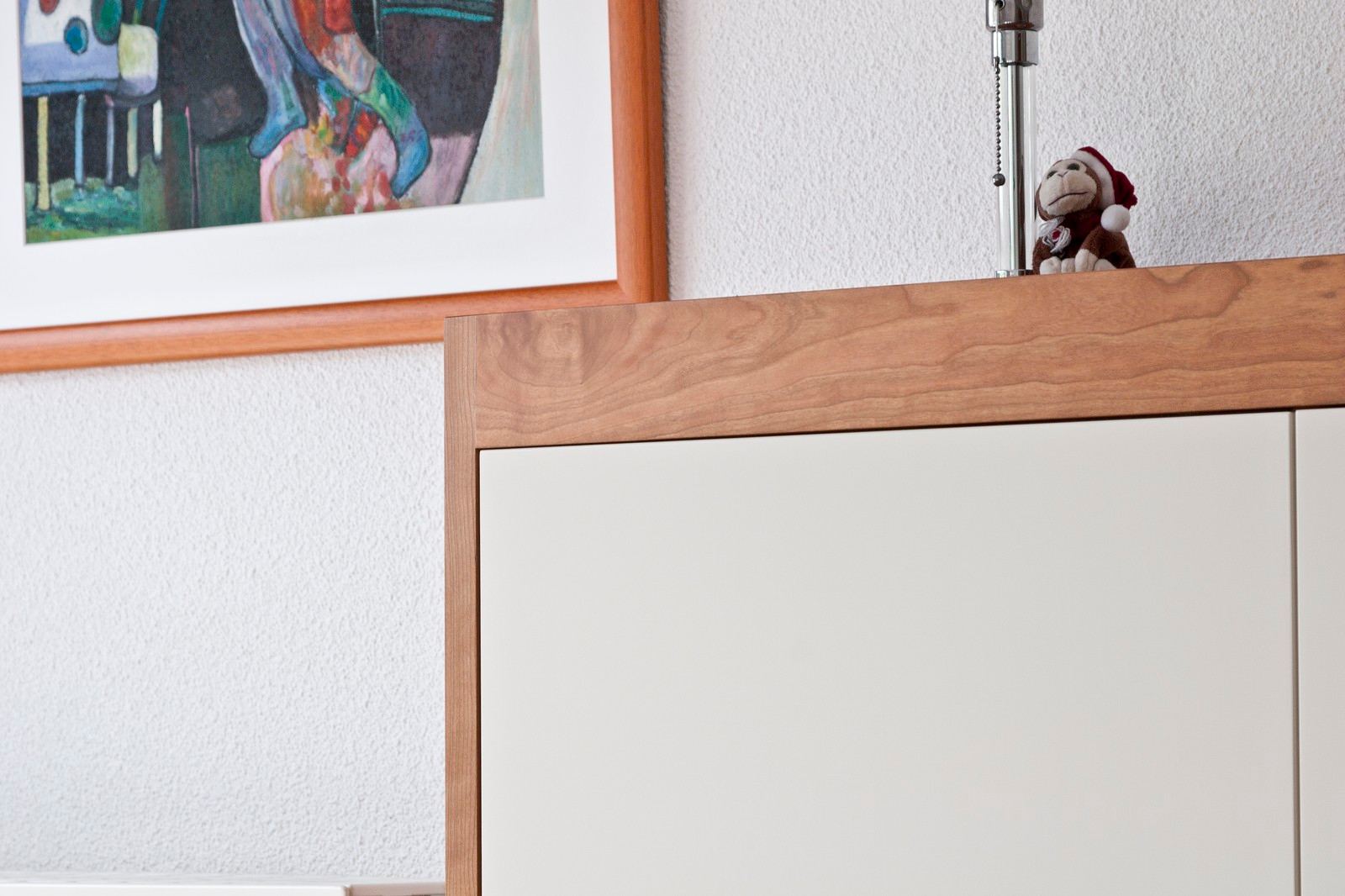 Hoek van het dressoir van dichterbij, met de houten rand boven een wit deurpaneel.