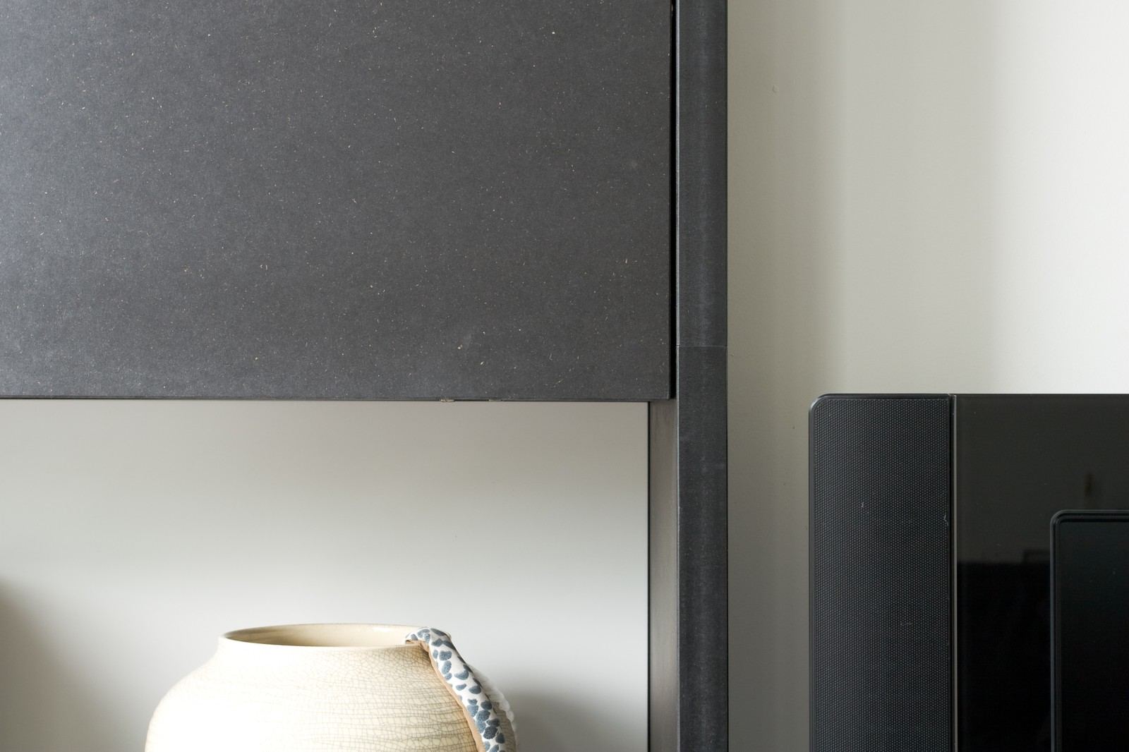 Detail van de zwarte MDF rand boven een open vak.