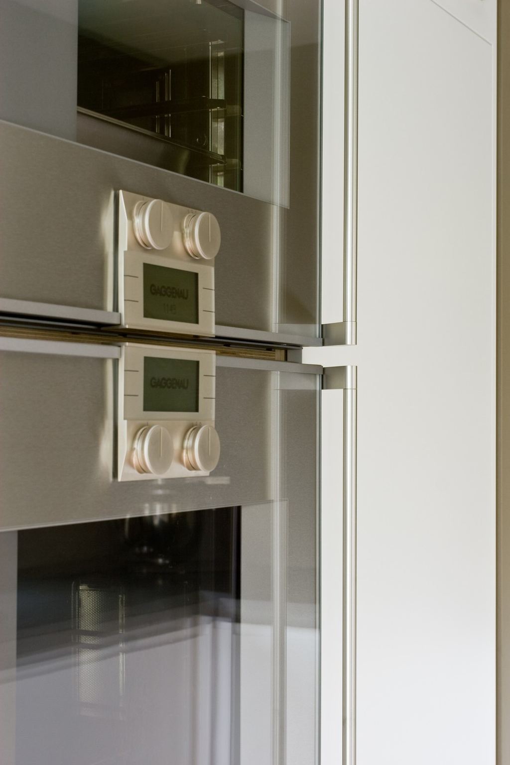 Detail van twee ingebouwde ovens met ronde bedieningsknoppen.