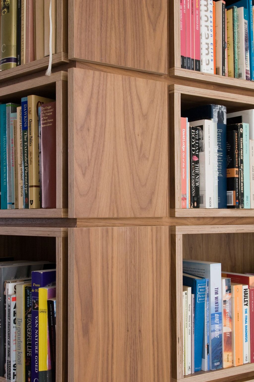 Detail van de kruisende naden tussen vier boekenkastvakken.