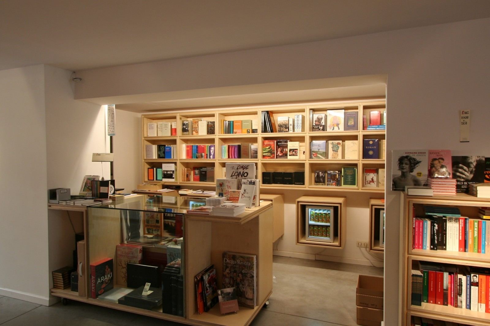 Stalen trap tussen boekenkasten met vakken voor kinderboeken.