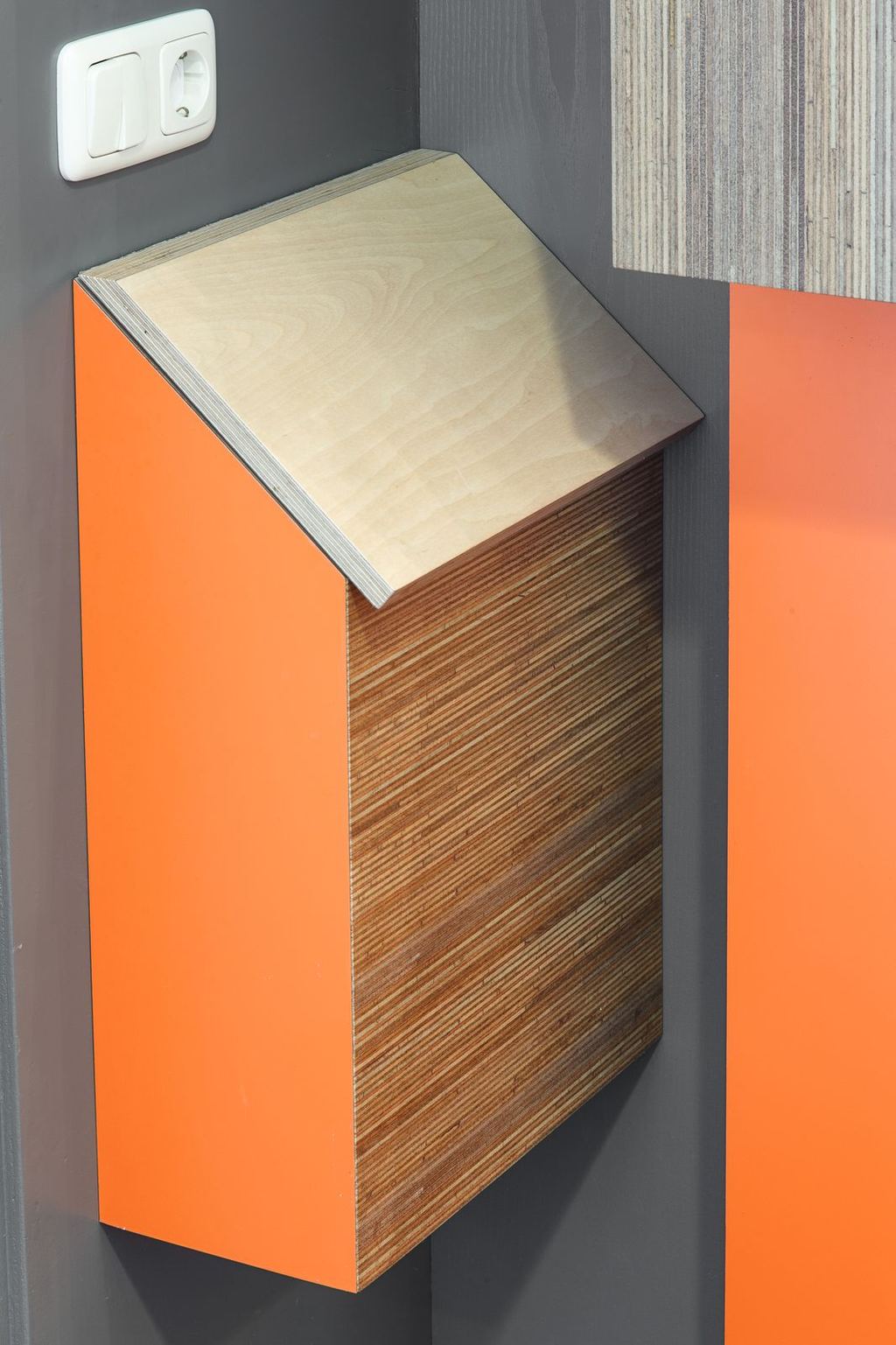 Zwevend wandkastje met oranje HPL front en zijkant in meranti plexwood.