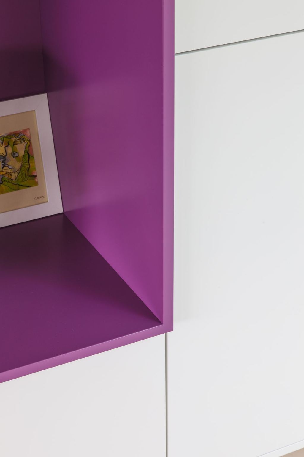 Detail van de paarse opening met een ingelijst kunstwerk.