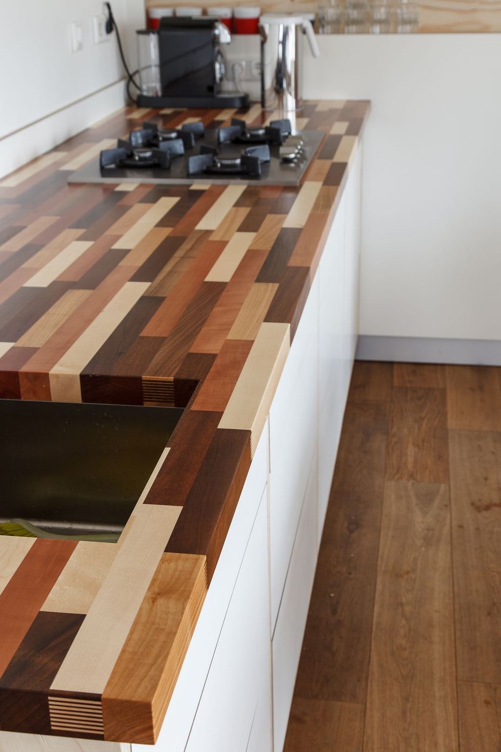Gestreept houten werkblad met een inbouwkookplaat, in verschillende houtkleuren.