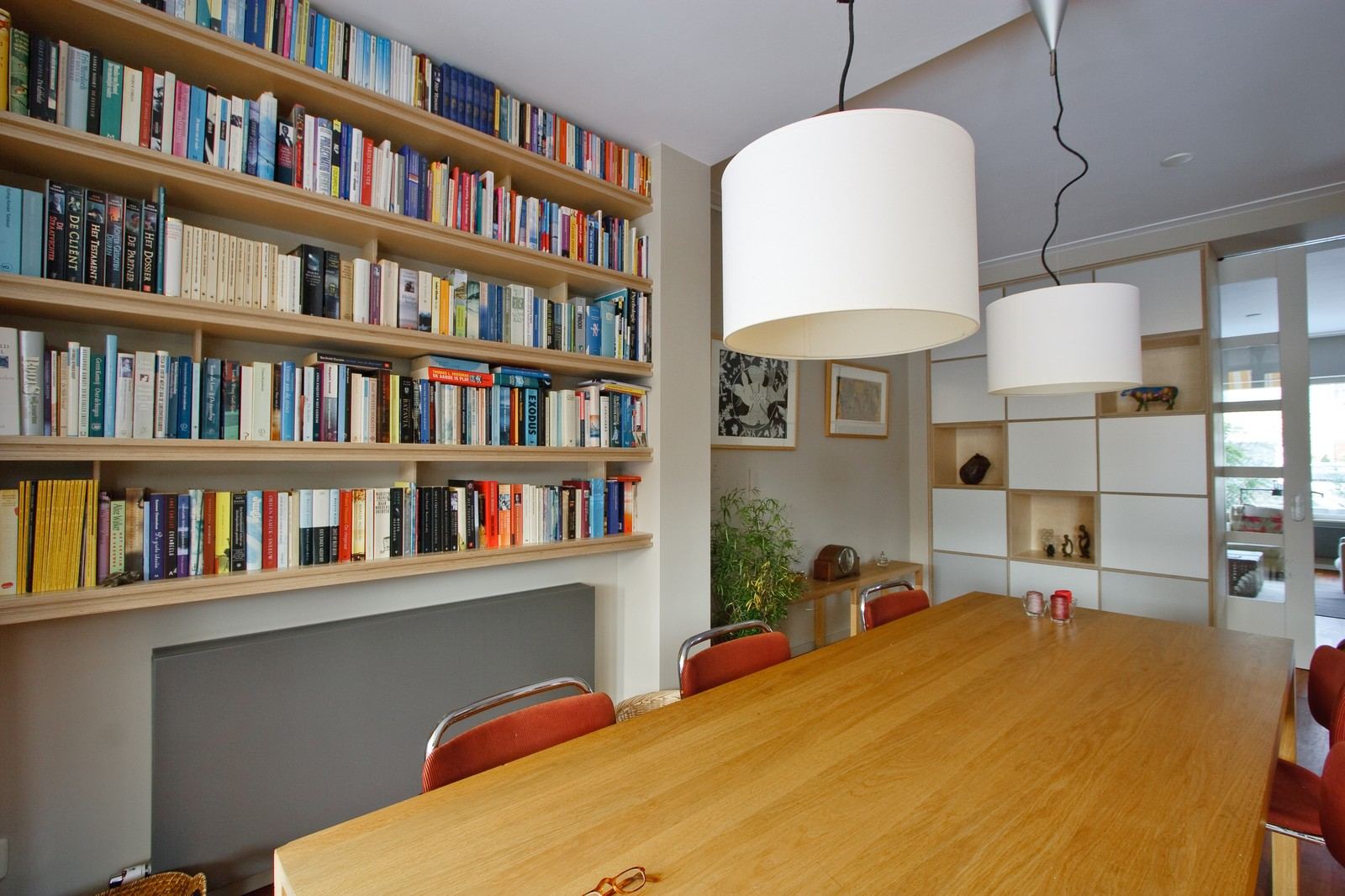 Boekenkast over de volledige breedte van de muur, met open planken.