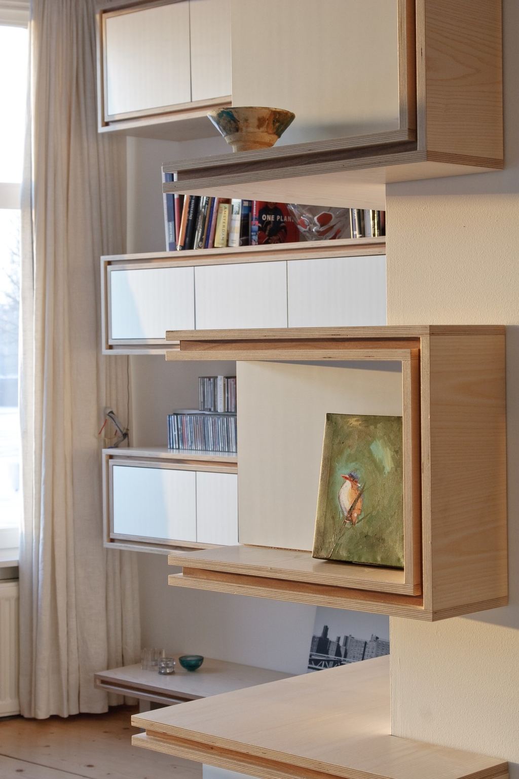Zwevende kastdelen slingeren van vloer tot plafond langs de hoek.