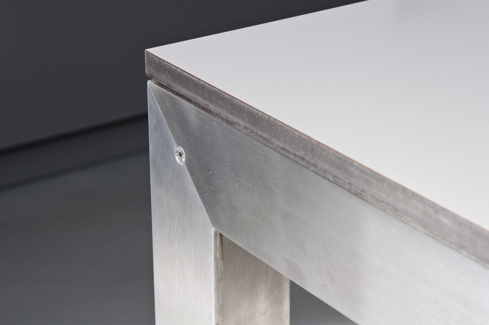 Close-up van de stalen poot en het HPL tafelblad.