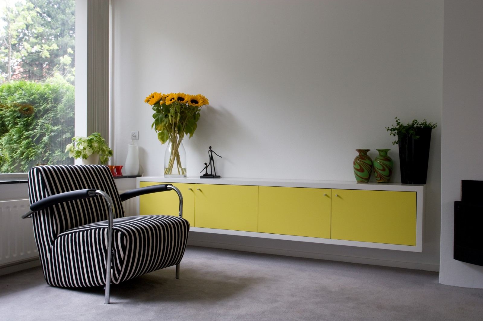 Lang zwevend dressoir met een witte romp en gele deuren.