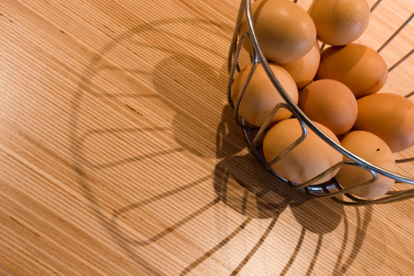 Close-up van een draadmandje met eieren op het werkblad.