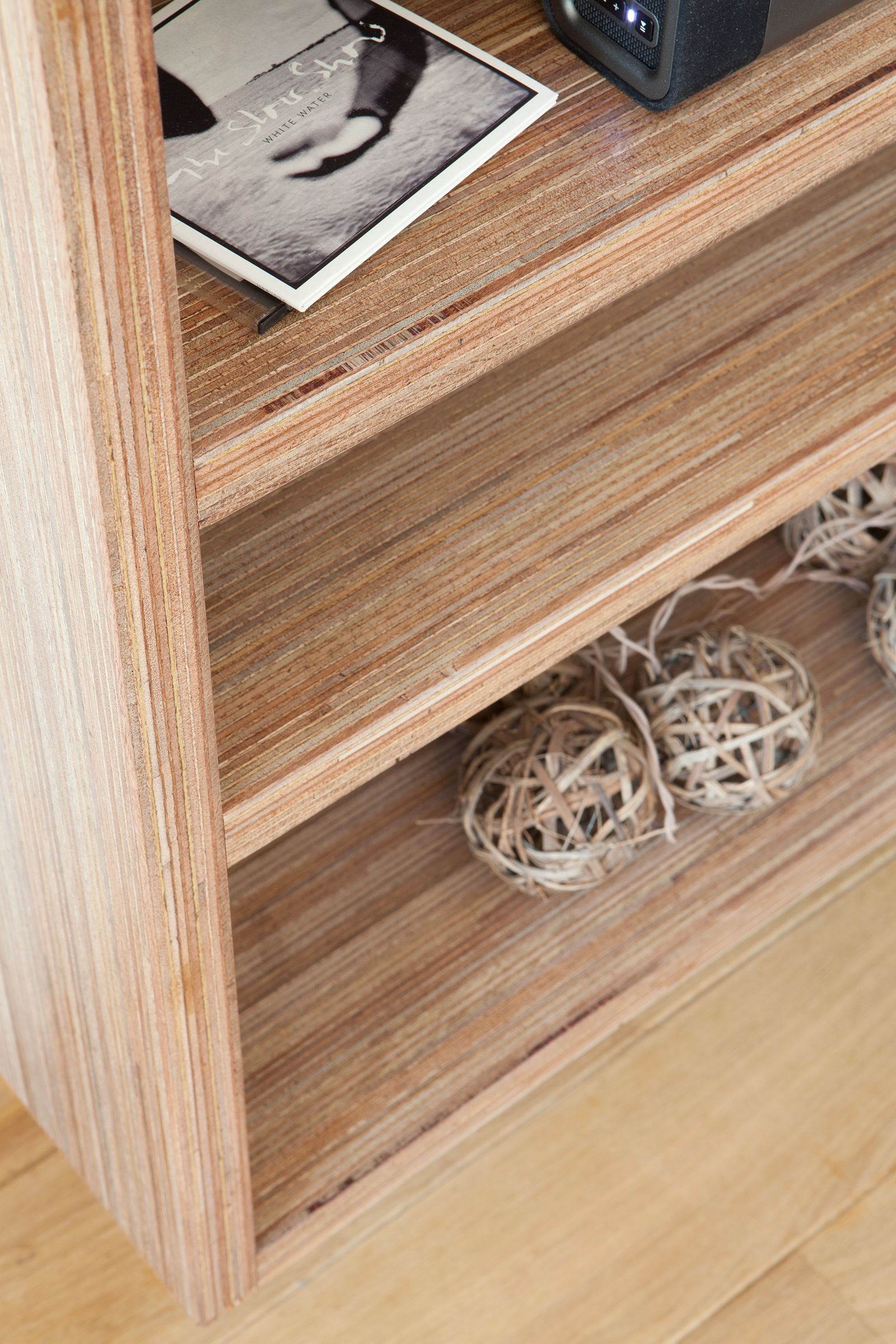Detail van een open plexwood legplank in de televisiekast.